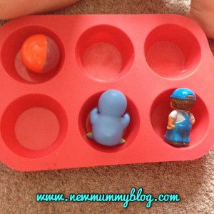 toddler using a muffin tray for sorting